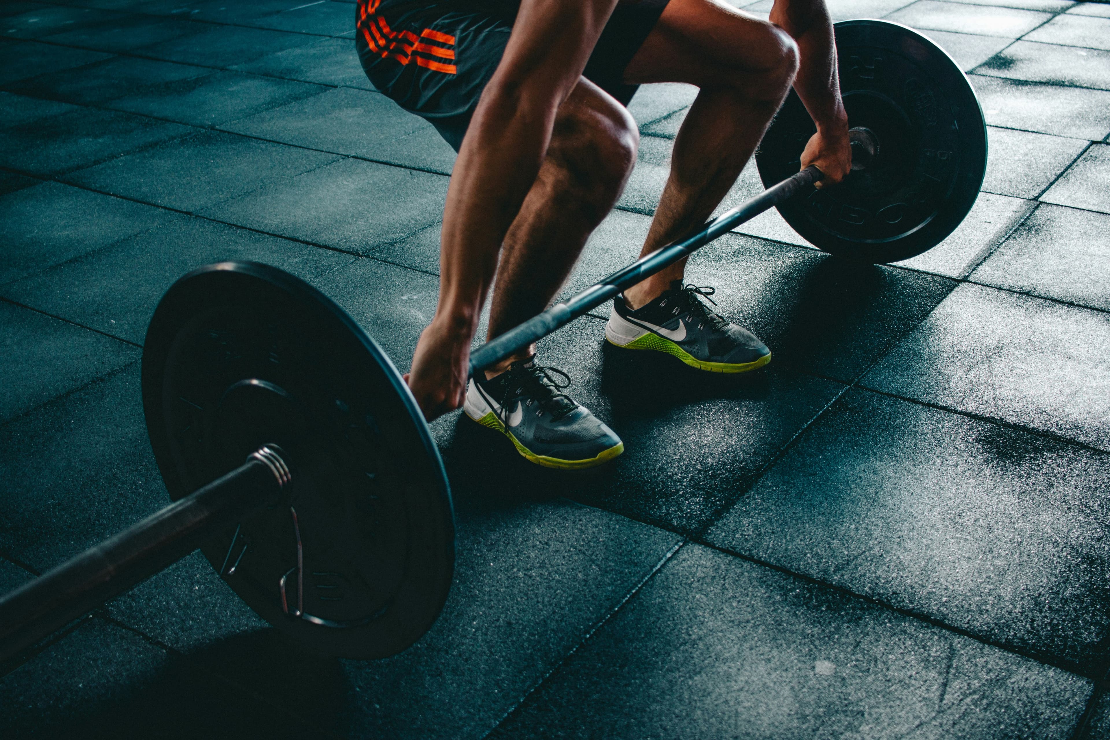 An athlete lifting a loaded barbell in a gym